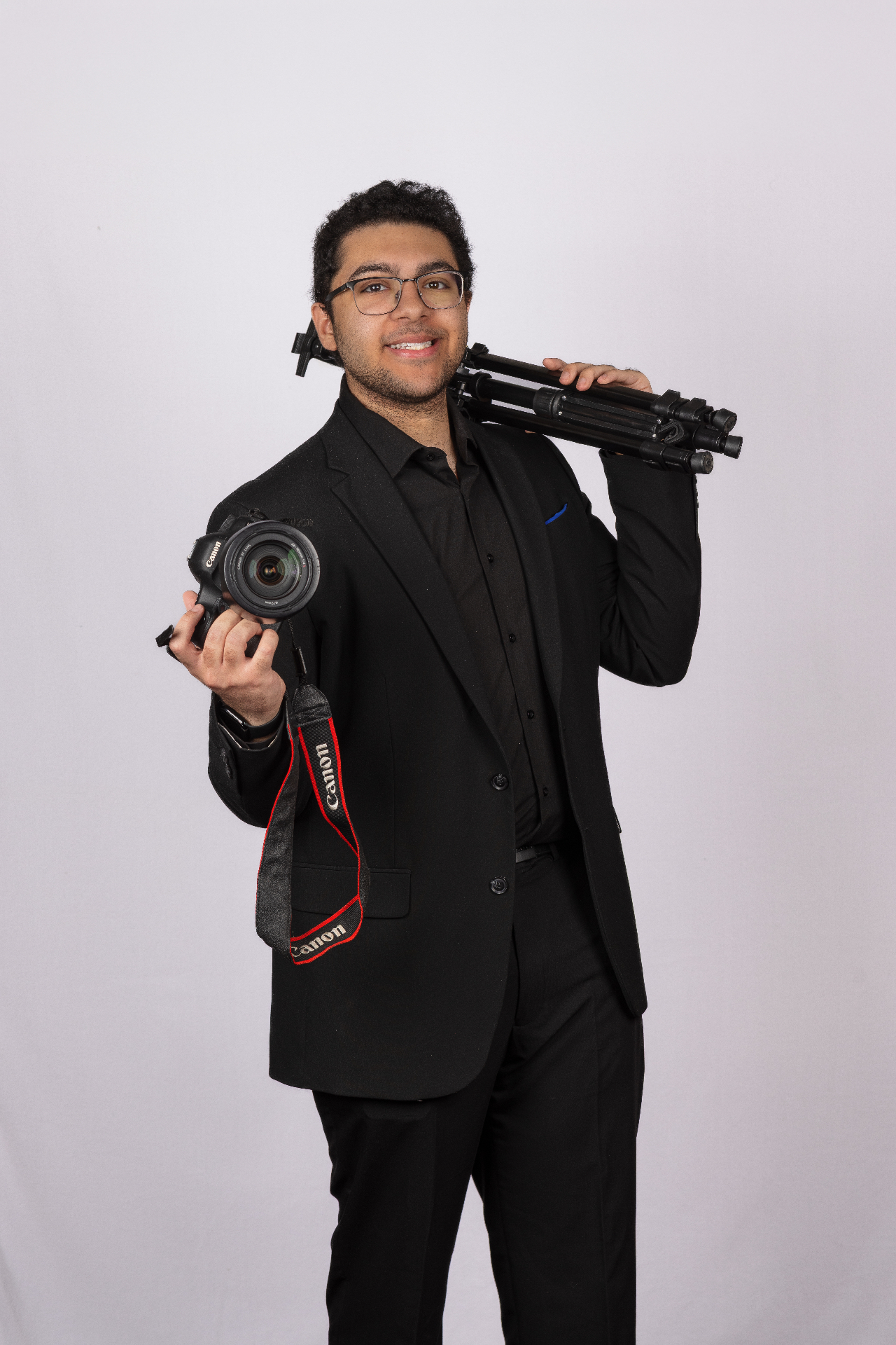 Andrew Thomas holding a Canon camera and tripod